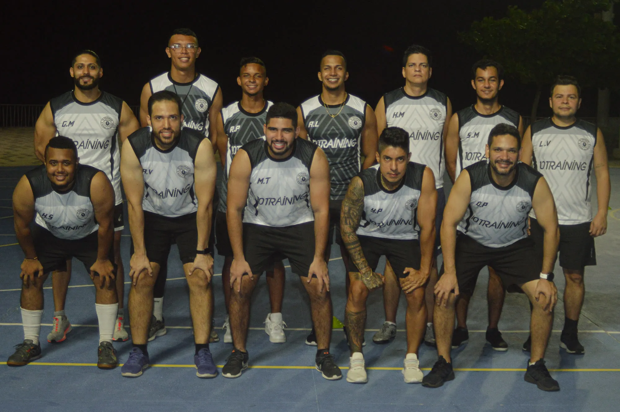Grupo de entrenamiento posando en la cancha al terminar la sesión nocturna