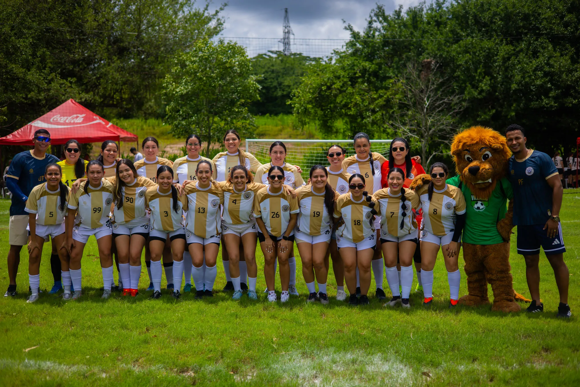 Plantel femenino junto al cuerpo técnico y la mascota del club al borde de la cancha