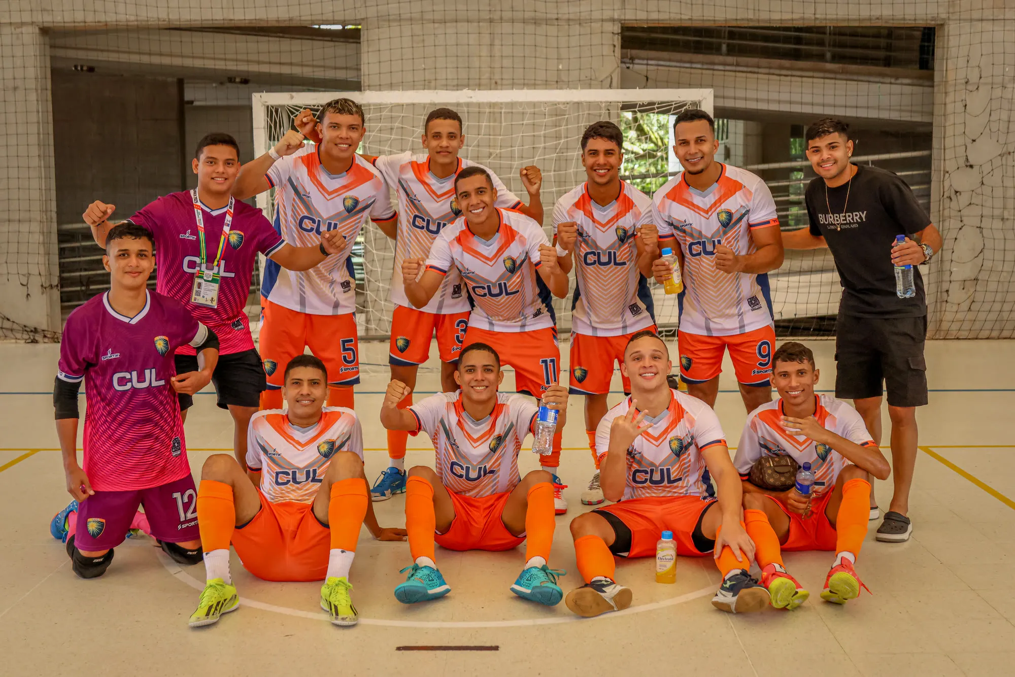 Plantel juvenil de fútbol sala celebrando en la cancha techada