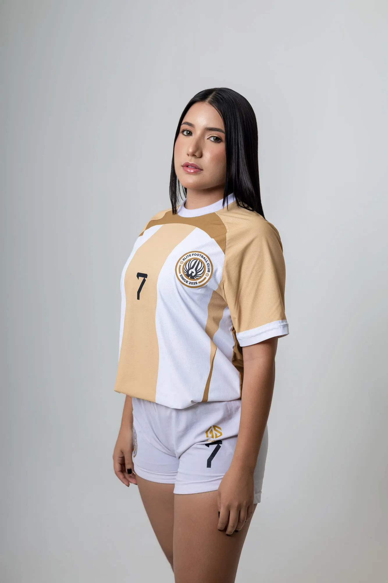 Jugadora número 7 de perfil en estudio, con la indumentaria blanca y dorada